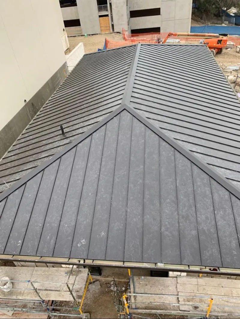 Commercial metal roof construction with crane equipment in Beacon Square